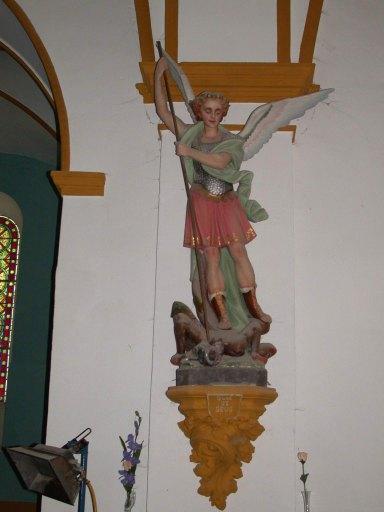Vue de la statue de saint Michel terrassant le démon sur une console.