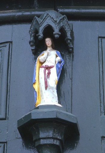 Vue de détail de la statuette de la Vierge en haut du portail.