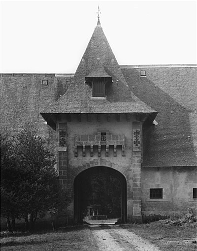Vue rapprochée de l'entrée : portail avec mâchicoulis.