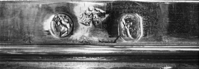 Détail des poinçons de garantie et de maître, sur le bord de la coupe.