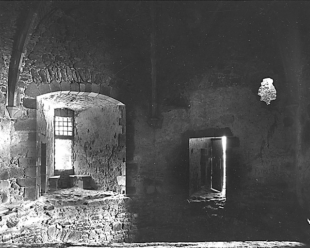 Intérieur du donjon. Premier étage. Vue partielle de la salle, prise en 1981, montrant la porte d'entrée et la fenêtre nord-ouest avec ses deux coussièges.