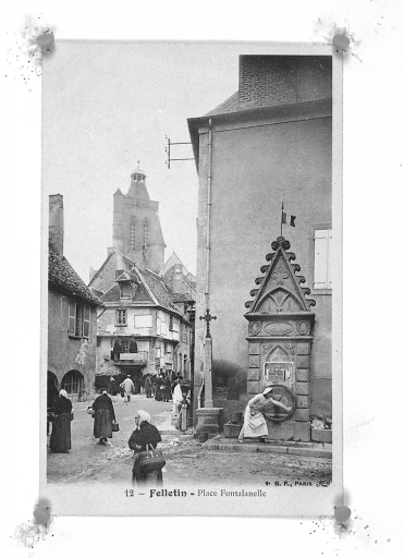 Grande Rue. Vue, depuis la rue Courte, de deux maisons situées à l'angle de la Grande Rue et de la rue des Fossés ; l'une des maisons (n°36 de la Grande Rue) présente des arcades marchandes, au rez-de-chaussée et l'autre, aujourd'hui démolie (remplacée par le n° 34 actuel de la Grande Rue), est construite en pans de bois et torchis et présente un deuxième étage en encorbellement ; au vu de la pancarte accrochée au premier étage, cette dernière maison abritait une 'teinturerie dégraissage' ; de grand écheveaux de laine sèchent en effet sur le balcon, à l'abris, sous l'encorbellement.