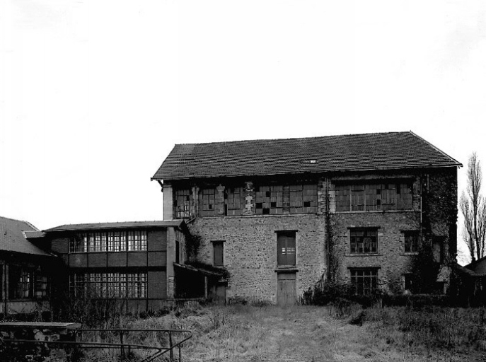 A gauche la passerelle reliant les parties est et ouest de l'usine. A droite un magasin industriel (ancienne salle des machines).