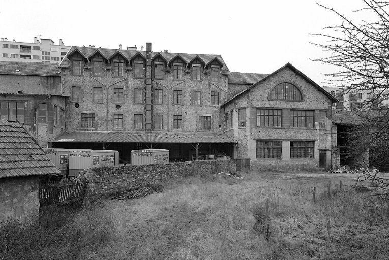 Façade est des locaux occupés par l'usine de meubles Arnaud à partir de 1946. Affectation de ces locaux dans les années 1890 : de droite à gauche les entrepôts de gazettes, le bâtiment du four à globe n° 11 (pignon avec baie en demi-cercle), atelier d'engazettage (bâtiment à lucarnes), bâtiment du four à globe n° 12 (angle nord-est).