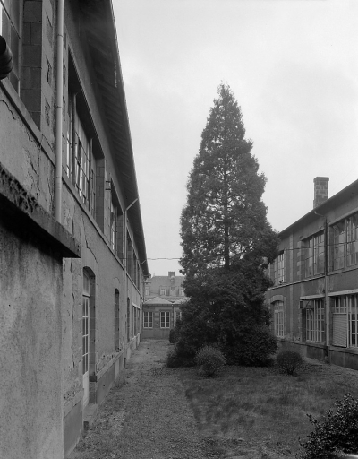 Cour intérieure des bureaux et magasin (anciens ateliers de décoration de 1853) vue du nord-ouest. Au fond, la toiture et les lucarnes de la façade postérieure du logement patronal.