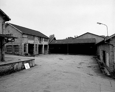 Hangars et dépôts : à gauche, l'atelier de mécanique et la cantine aménagée à l'étage vers 1960. Au fond, une remise de voitures. A droite, la réserve de fûts en bois, puis la cannetterie.
