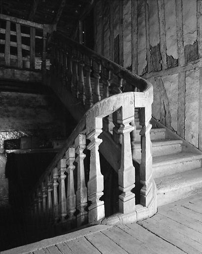 Intérieur du château. Vue d'ensemble de l'escalier en bois et de sa rampe à balustres, depuis le palier de l'étage.