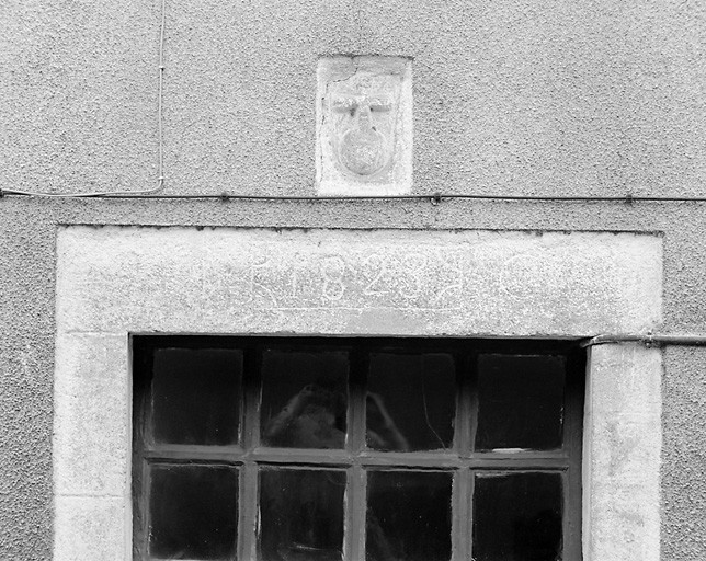 Elévation sud. Détail de la porte au linteau portant la date '1823' et surmonté d'une croix sculptée.