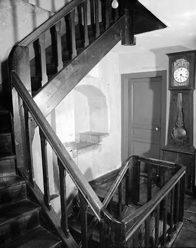 Intérieur. Vue partielle, au niveau du palier du premier étage, de l'escalier tournant et d'un ancien évier en pierre aménagé dans le mur pignon.