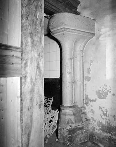 Intérieur. Rez-de-chaussée. Vue du jambage droit d'une ancienne cheminée en pierre, en partie cachée dans l'ancien local professionnel.