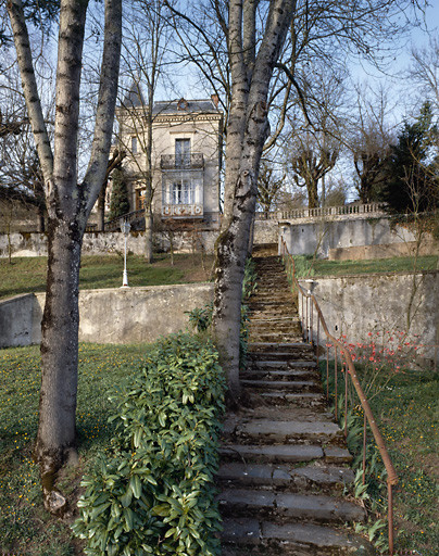 Vue d'ensemble, depuis le sud, avec en premier plan, l'escalier qui traverse le jardin et qui mène à la maison.