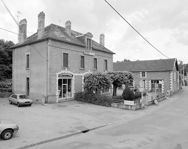 Vue d'ensemble d'un hôtel restaurant et de ses dépendances situés à l'Aiguille. Inscription : 'C 1911 D' gravée à la base de la devanture en pierre de la lucarne.