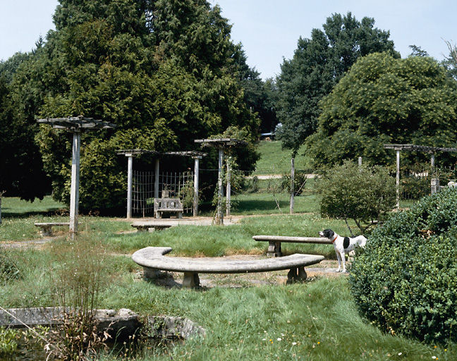 Vue partielle de la roseraie avec bancs et pergola.