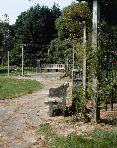 Vue partielle de la roseraie avec bancs et pergola.