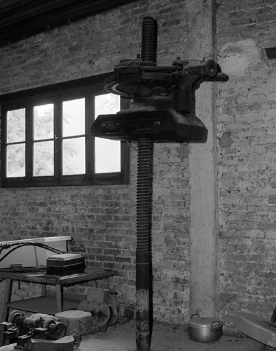 Intérieur de l'ancien moulin transformé en cartonnerie. Vue d'une presse.