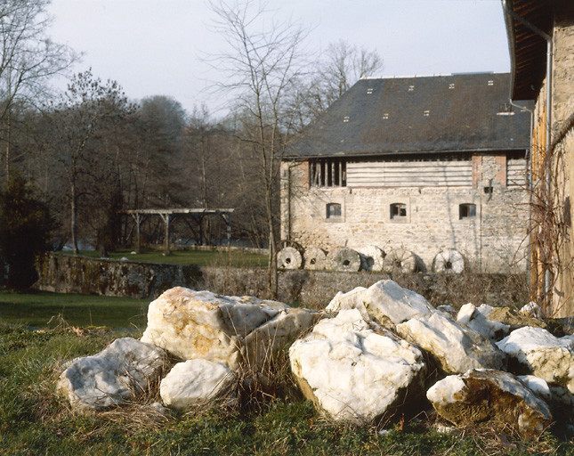 Vue d'ensemble du moulin avec tas de quartz au 1er plan.
