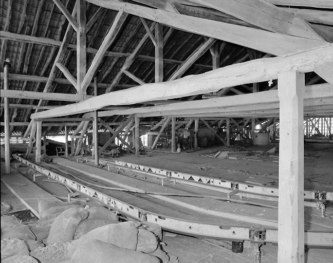 Bâtiment A. Intérieur. Vue partielle de l'étage des combles, ou ancien séchoir, avec les rails permettant d'apporter la matière première dans les trémies.