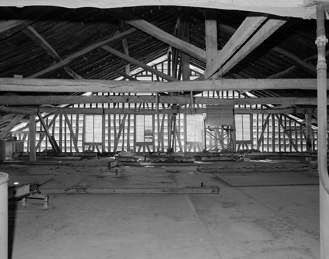 Bâtiment A. Intérieur. Vue d'ensemble de l'étage des combles ou ancien séchoir, avec les rails permettant d'apporter la matière première dans les trémies.