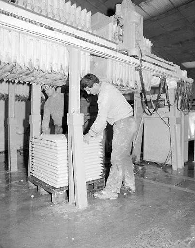 Bâtiment I ou atelier de filtre-pressage et désaérage. Ouvriers rangeant sur une palette les galettes sorties d'un filtre-presse.