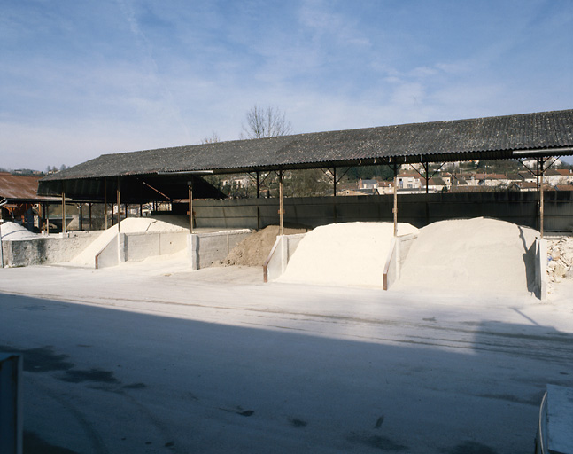 Vue d'ensemble du stockage de matières premières dans hangars compartimentés.