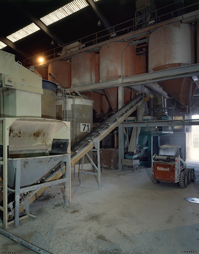 Salle de broyage. Vue des silos de stockage et pressage.