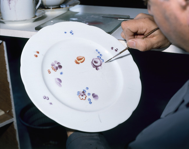 Décor à la main. Application du décor de peinture, au pinceau, sur une assiette.