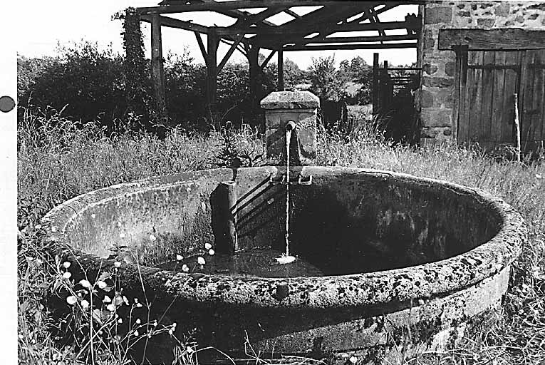 Le Moulin du Bois. Fontaine avec bassin situés dans une cour de ferme.