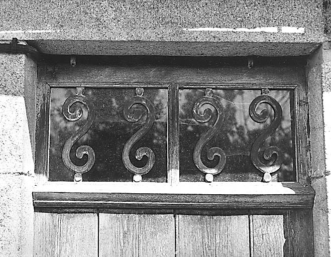 Les Grotonnières. Logis de ferme. Cadastre 1986 B6 1276 ou 1423. Détail de l'imposte de la porte, ornée de volutes en bois.
