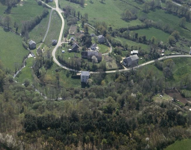 Vue aérienne du site du château. Vue générale depuis le nord du promontoire du château ceinturé par le ruisseau de la Cazine.
