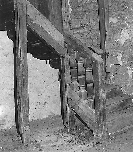 Intérieur du logis. Vue partielle de l'escalier menant à l'étage de comble avec rampe ornée de balustres.