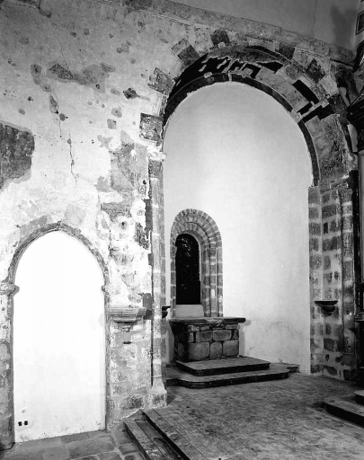 Vue de l'absidiole est du transept sud. Cette vue montre les peintures murales ornant l'arcade de l'absidiole et le mur du transept ainsi que la verrière de l'absidiole, oeuvre de F. Chigot reposée à cet emplacement en 1996.