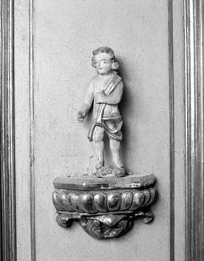 Détail : lambris du pilier sud de l'arc triomphal, statuette de putto sur une console.