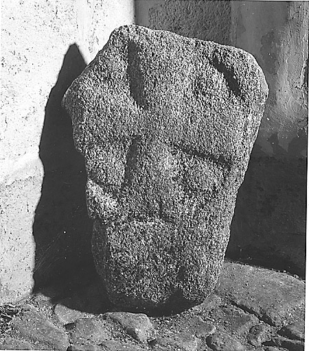 Pierre en granite ornée d'une croix pattée sculptée dans la masse.