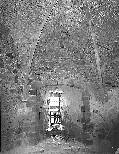 Intérieur du donjon. Premier étage. Vue partielle de la salle, prise en 1997, montrant la fenêtre nord-ouest avec ses coussièges, la porte menant à l'escalier en vis qui conduit à l'étage et une partie de la voûte d'ogives.