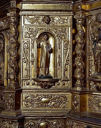 Détail du pan droit de l'armoire du tabernacle supérieur : dans la niche statuette de saint diacre tonsuré tenant un livre.