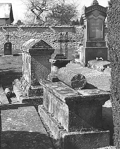 Section A, vue partielle. Au premier plan, tombe autrefois surmontée d'une colonne ; à l'arrière, haute tombe à couverture en bâtière et à sa droite, croix en fer à décor ajouré surmontant une dalle funéraire.