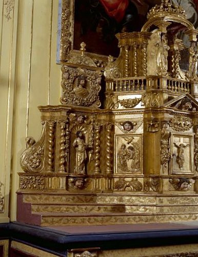 Détail du côté gauche du tabernacle : sur l'aile statuette de saint Pierre, au-dessus le buste du Christ dans un médaillon ; sur le pan gauche de l'armoire eucharistique, panneau sculpté de l'Annonciation.