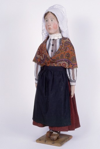 Paysanne en jupe rouge et tablier noir : vue de trois-quarts droite après restauration.