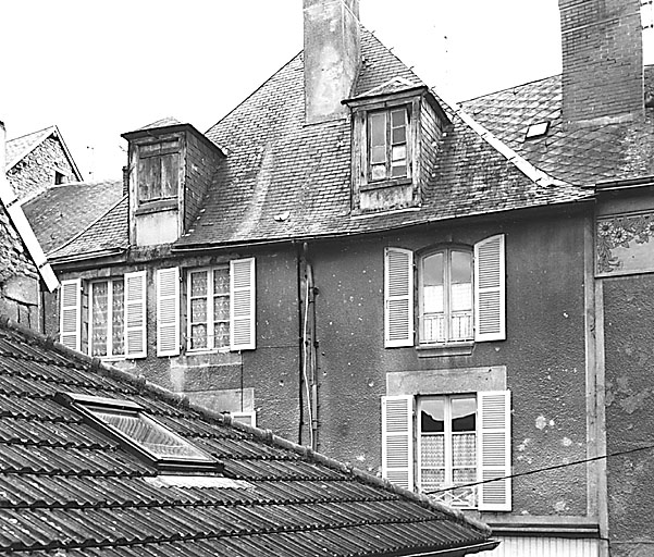 La Souterraine, ville. 9, 7 rue des Toiles. Maison construite sur une ou deux parcelles médiévales et datant vraisemblablement de la fin du 18e siècle ; aujourd'hui elle constitue deux éléments d'habitation, avec chacun son accès, l'un, au sud, à deux travées et l'autre, au nord, à une travée. Vue partielle de la partie supérieure de l'élévation sur rue montrant les deux étages carrés, l 'étage des combles et la croupe du toit en façade. Cadastre 1992 BD 308, 309.