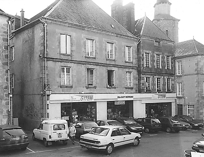 La Souterraine. Maisons, 4, 6 place du Fort (cadastre 1992, BD 318, 94). Maisons vraisemblablement implantées sur trois parcelles médiévales, discernables par la structure de trois caves. Maisons très caractéristiques d'un bâti sostranien, avec mur de croupe en façade, cette dernière, à plusieurs travées, rythmée par un bandeau plat et une corniche moulurée. Vue d'ensemble des élévations antérieures.