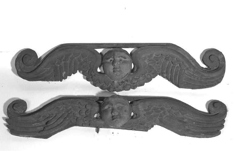 Bas-reliefs représentant des têtes d'anges ailées (vraisemblablement anciens éléments de retable). Vue de face.