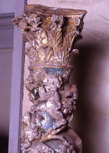 Détail de la partie haute d'une colonne : putto sonneur de trompette et chapiteau.