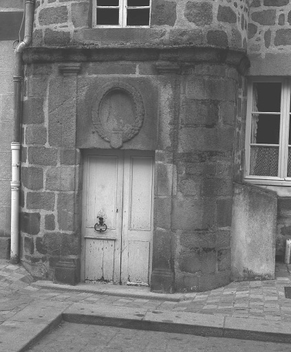 3 place Courtaud ; rue du Clocher. Hôtel (AL 42, 43). Vue de la porte de la tour d'escalier dont le linteau, de grande hauteur, est orné d'un décor sculpté représentant une grande couronne de laurier agrémentée d'un écu.