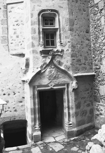 Tour en demi hors oeuvre abritant l'escalier en vis. Vue, après restauration, de la porte surmontée d'un écu bûché et d'un gable, orné d'une rose sculptée à la pointe de l'accolade. L'encadrement de la porte présente cette mouluration particulière formant sur le linteau un V inscrit dans une accolade.