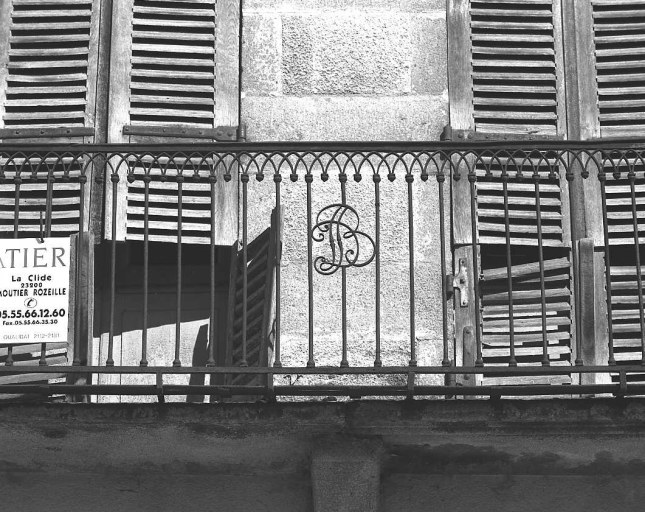 Elévation antérieure donnant sur la place. Vue de détail du monogramme 'D B' ornant le garde corps en fer forgé du balcon du premier étage.