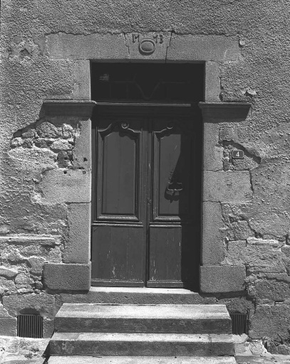 4 rue des Ecoles ; rue Pelleterie. Hôtel (AK 180, 181, 163). Vue de détail de l'élévation antérieure montrant la porte d'entrée. Le claveau central du linteau est orné d'un décor sculpté représentant un cartouche ovale et mouluré accosté des chiffres de la date '1773' ; les panneaux supérieurs des vantaux présentent une mouluration chantournée et le vantail droit a conservé son heurtoir.