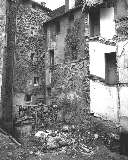 Vue partielle de l'élévation ouest donnant sur la cour accessible par la rue Détournée, depuis la démolition de bâtiment au toit formant terrasse et de la tour en brique qui abritait un escalier ; cette vue montre les encadrements de baies anciennes murées, dissimulées sous le crépi.