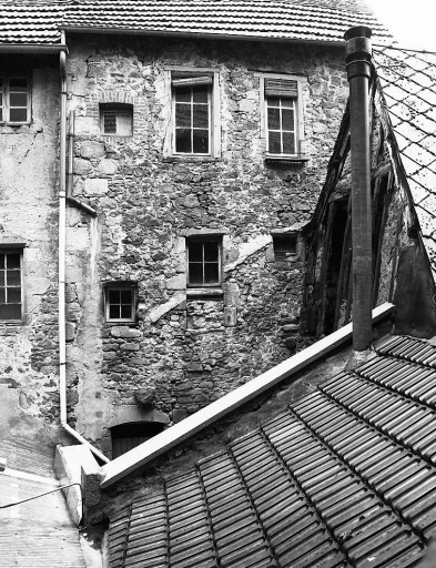 1 Grande rue ; rue des Tours de l'Horloge. Maison (AM 58). Elévation sud-est donnant sur une cour. Cette élévation ancienne porte les traces de remaniements divers : percement de baies avec encadrement constitué de pierres de remploi ou avec encadrement traité en bois ou en brique.