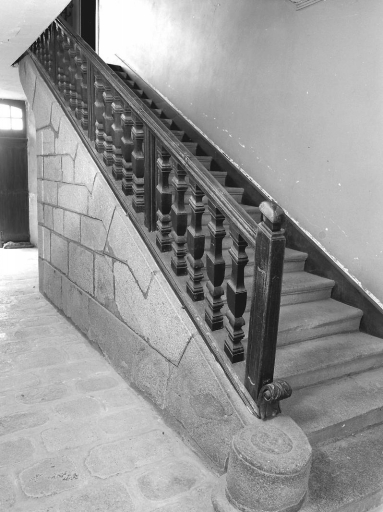 Vue, depuis le vestibule du rez-de-chaussée, de l'escalier droit, en pierre et de sa rampe à balustres tournés.