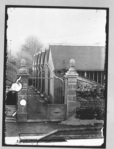 Vue, depuis la rue des Fossés, du portail menant à l'ancien jardin d'agrément et dans lequel ont été construits à partir de 1909 des ateliers de tapissiers, qui ont été démolis vers 1970. Photographie réalisée dans la première moitié du 20e siècle.